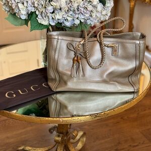 Gucci gold tote with braided handle and tassel
